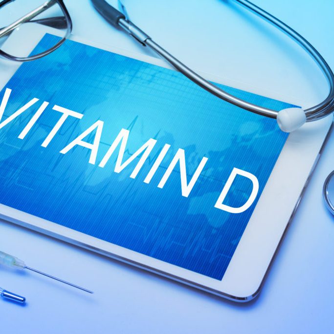 Vitamin D word on tablet screen with medical equipment on background